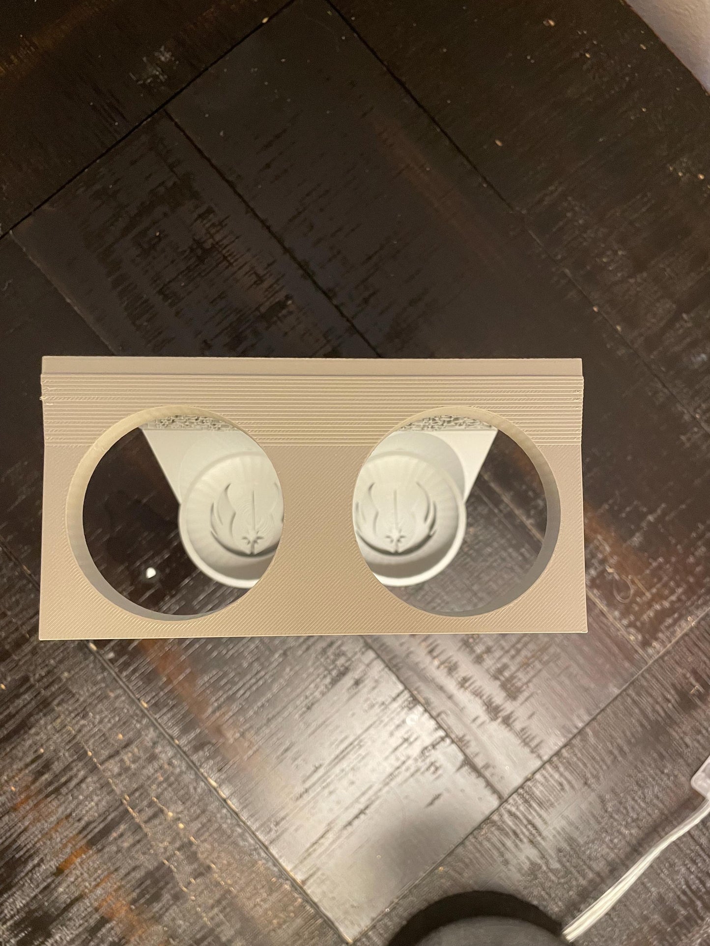 Savis Workshop Dual Lightsaber Mount shown here in the gray variant sitting on a table This vertical wall lightsaber mount is custom made to order every time. The aurebesh inscription is customizable as well as the logo in the hilt base.